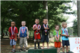 Six children standing on podiums with medals