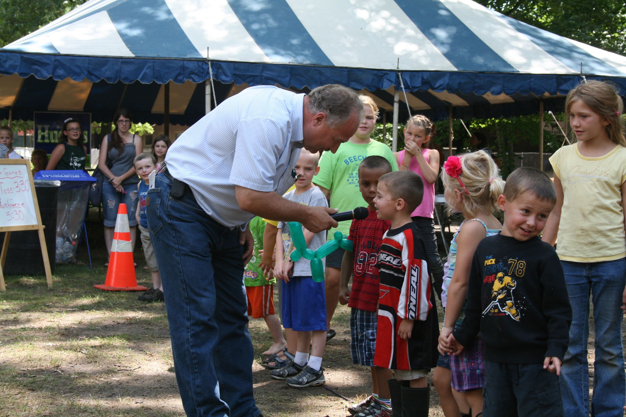 Image of older man talking with children at the fair