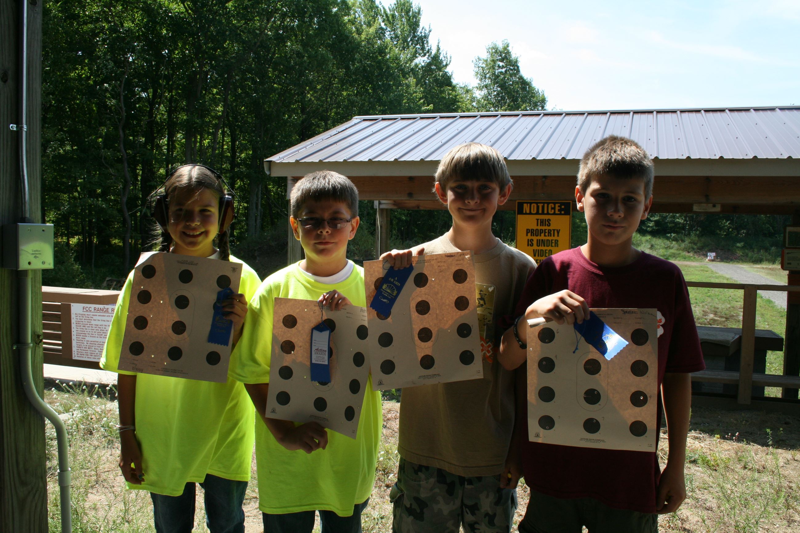 Four children showing shooting scores