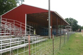 Image of bleachers and a red pole barn